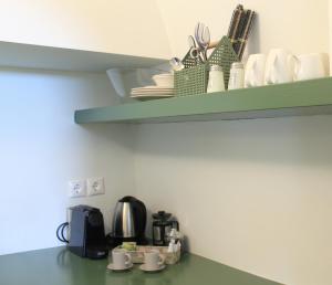 a shelf with cups and dishes on top of a kitchen counter at OUTOPOIA CAVE STUDIOS in Oia