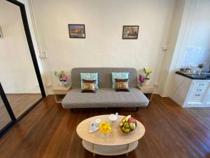 ein Wohnzimmer mit einem Sofa und einem Tisch mit Obst in der Unterkunft 1 min walk to BTS, 3 Bed 3 Bath, Entire House in Bangkok