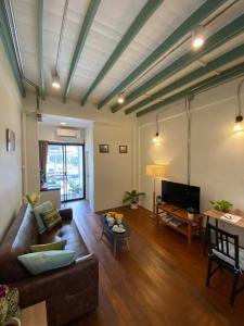 ein Wohnzimmer mit einem Sofa und einem Tisch in der Unterkunft 1 min walk to BTS, 3 Bed 3 Bath, Entire House in Bangkok