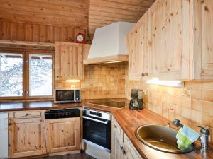 ナンダにあるChalet mit Saunabereich - CH 383.014のキッチン(木製キャビネット、シンク、コンロ付)