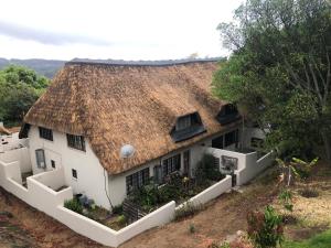 a large white house with a thatched roof at Villa Jullienne - A Home Away From Home - Unit 9 in Nelspruit