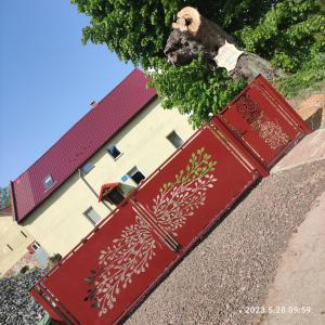 two red doors with flowers painted on them in front of a building at Apartament pod Lipą in Kłodzko