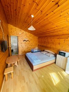 シュヴェントイにあるŽuvėdrų 30の木製の部屋にベッド1台が備わるベッドルーム1室があります。