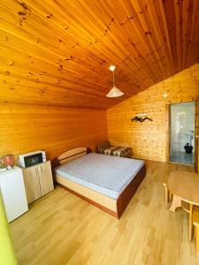 什文托伊的住宿－Žuvėdrų 30，一间卧室设有一张床和木制天花板