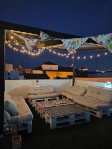 uma sala de estar com sofás, uma mesa e luzes em Vivian's Guest House em Jerez de la Frontera