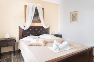 a bedroom with a bed with two towels on it at Alexandros by the Beach - Serifos in Livadakia