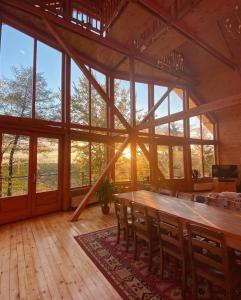 Habitación grande con mesa de madera grande y sillas. en Carpathian Log Home, en Bran