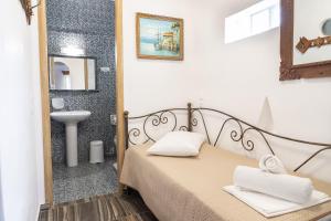a bedroom with a bed and a sink and a mirror at Alexandros by the Beach - Serifos in Livadakia
