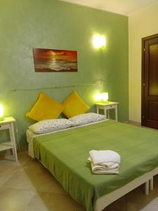 マルツァメミにあるIl Poggetto Marzamemi B&Bのベッドルーム1室(大きな緑色のベッド1台、テーブル2台付)