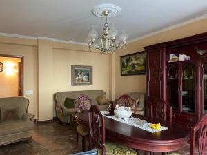 comedor con mesa, sillas y lámpara de araña en Apartamento de 4 habitaciones en Cabo de Cruz, en Boiro
