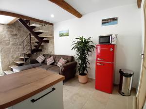 a living room with a red refrigerator and a couch at H2o Chambres d'Hôtes in Peyriac-de-Mer