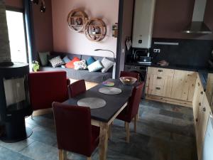 cocina con mesa, sillas y sofá en Home Relax Perche : gîte avec prestations bien-être en Montigny-le-Chartif
