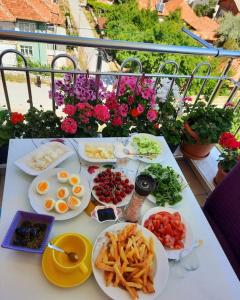 uma mesa com pratos de comida numa varanda em My Home em Beysehir