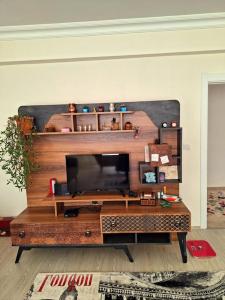 uma sala de estar com televisão numa mesa de madeira em My Home em Beysehir