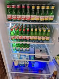 a refrigerator filled with lots of bottles of soda at My Home in Beysehir
