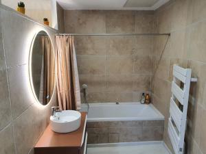 a bathroom with a tub and a sink and a mirror at H2o Chambres d'Hôtes in Peyriac-de-Mer