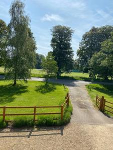 una carretera con una valla y un campo con árboles en Kings Arms Annex en Steventon