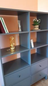 una estantería azul con estanterías vacías en Tatanya Panzió, en Tata