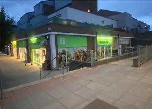 a store front with green signs on a city street at Hamble Lounge - Accomodation for Aylesbury Contractors & Industrial estate - Free Parking & WIFI Sleeps up to 6 people in Buckinghamshire