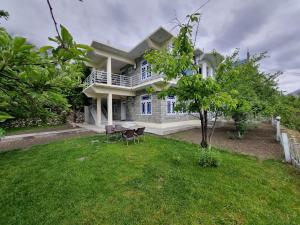 a house with a yard with chairs in front of it at Royal's Villa by Premiere Inn, Hunza in Hunza