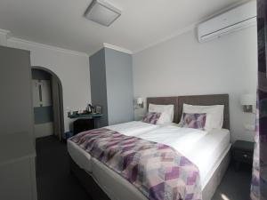 1 dormitorio con 1 cama blanca grande con almohadas en Wegzen, en Hévíz