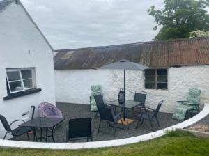 een patio met een tafel en stoelen en een parasol bij Big Anthony’s in Greencastle