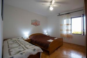 um quarto com uma cama e uma janela em Apartments Davorka Šimuni em Simuni