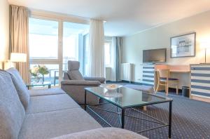 a living room with a couch and a table at Aparthotel Zingst in Zingst