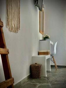 Zimmer mit einem weißen Schreibtisch und einem Stuhl in der Unterkunft Nostos Studios in Parikia