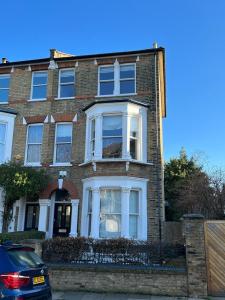 a large brick house with white windows on a street at Bright and Modern 2 bed flat in London