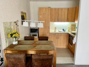 a kitchen with a wooden table with chairs and a kitchen with a counter at RuheZeit - inclusive Pool & Sauna in Bad Harzburg