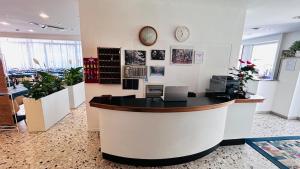 an office with a counter with a clock on the wall at Hotel Sorriso in Cattolica