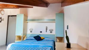 a bedroom with a bed with a blue comforter at Hotel Sorriso in Cattolica
