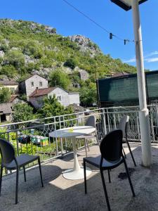een tafel en stoelen op een balkon met een berg bij Honey Home in Podgorica