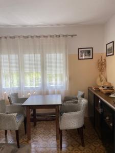 een eetkamer met een tafel en stoelen en een raam bij Honey Home in Podgorica