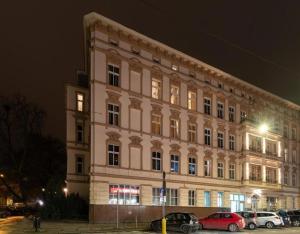 um grande edifício com carros estacionados em frente em Kamienica Centrum Apartament nr 17 em Szczecin