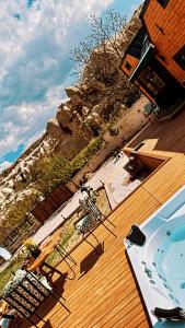 a deck with a swimming pool and a wooden deck with a hot tub at Cappatiny House in Goreme