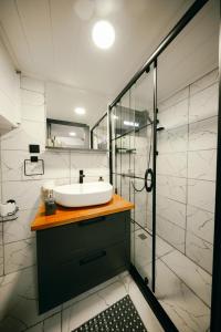 La salle de bains est pourvue d'un lavabo et d'une douche en verre. dans l'établissement Cappatiny House, à Gorëme