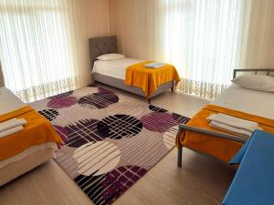 a room with two beds and a rug at My Home in Beysehir