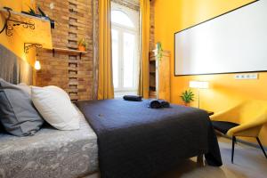 a bedroom with a bed and a large screen at BudapeStayz - Raday Rooms in Budapest