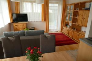 un soggiorno con divano e TV di Apartment Neuhauser a Kramsach