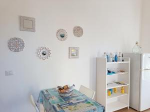 ein Esszimmer mit einem Tisch und einem Kühlschrank in der Unterkunft La prima casa in Polignano a Mare