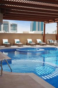 a swimming pool on the roof of a building at La Maison Hotel Doha in Doha