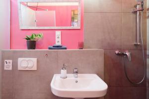 a bathroom with a sink and a shower with a mirror at BudapeStayz - Raday Rooms in Budapest +74 photos