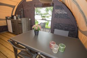 a table in a tent with flowers on it at Camping Recreatiepark Aalsmeer in Aalsmeer