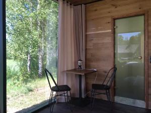 two chairs and a table in a room with a window at Kuldi Mirror House 