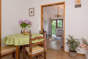 una sala da pranzo con tavolo e vaso di fiori di Cosy apartment Greta a Kaštelir (Castellier)
