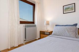 una camera con un letto bianco e una finestra di Cosy apartment Greta a Kaštelir (Castellier)