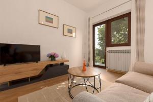 un soggiorno con TV a schermo piatto e tavolo di Cosy apartment Greta a Kaštelir (Castellier)