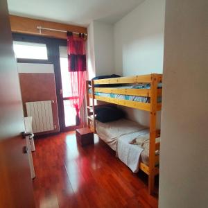 1 Schlafzimmer mit 2 Etagenbetten und Holzboden in der Unterkunft Trilocale centrale in Seregno